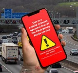 Ostrzeżenie dla kierowców, aby nie dotykać telefonów podczas testu alarmowego